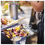 Shiny metal skewers with colorful veggies on grill.