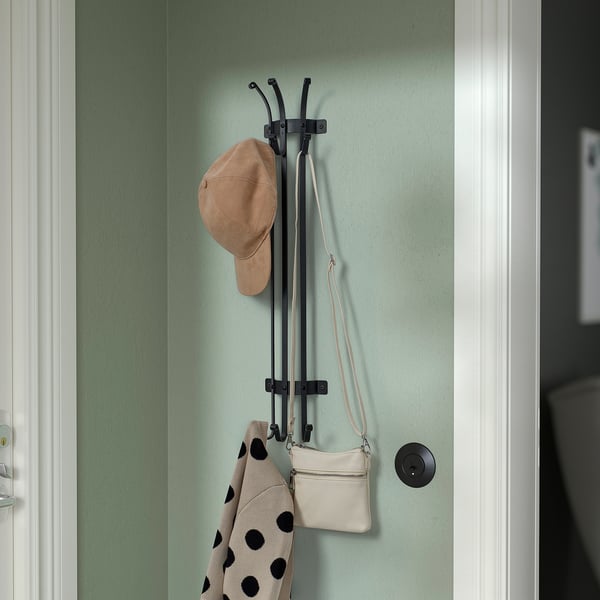 Wall-mounted coat hanger with hat, bag, and coat. Space-saving design for entryways or bedrooms.