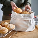 Hands placing rolls in cloth bag, more cooling on rack.