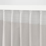 White sheer curtains with hooks, offering privacy and light diffusion.