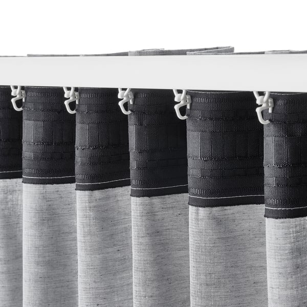 Blackout curtains with hooks hang from white rod, providing privacy and light control.