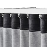Blackout curtains with hooks hang from white rod, providing privacy and light control.