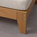 Wooden outdoor furniture close-up, showcasing smooth finish and sturdy construction. Cushion is plush and securely fastened.