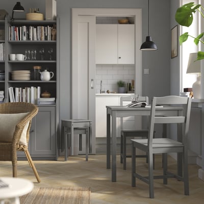 Modern gray dining set with wooden table and chairs, near kitchen entrance.