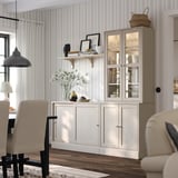 HAVSTA white sideboard with glass cabinet, striped wallpaper, beige chairs, wooden floor, decor.