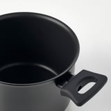 Close-up of black pots rim and sturdy handle, showcasing smooth interior and durable design.