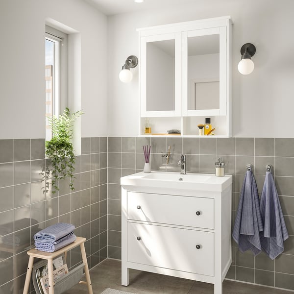 Modern bathroom with HEMNES vanity, mirrored cabinet, and blue towels.