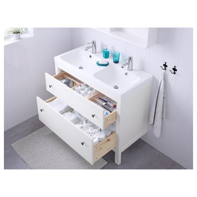 White bathroom vanity with open drawers showing towels and toiletries; silver fixtures, blue accents.
