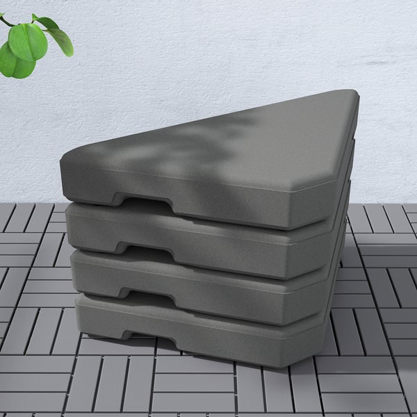 Stacked grey heavy duty parasol bases on wooden deck.
