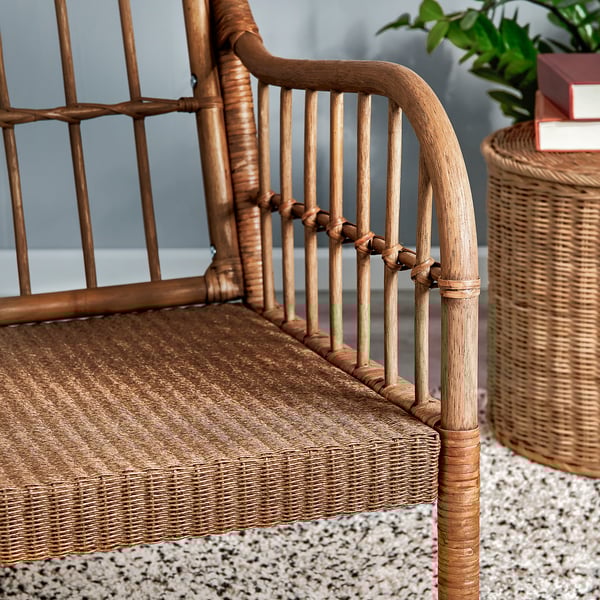 Handwoven rattan armchair with bamboo and wood details, showcasing natural textures and craftsmanship.
