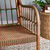 Handwoven rattan armchair with bamboo and wood details, showcasing natural textures and craftsmanship.