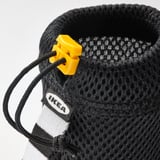 Black mesh bottle carrier with yellow drawstring stopper and IKEA tag.