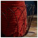 Red metal basket, intricate design, sturdy build for storage.