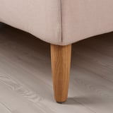 Upholstered bed with curved wooden legs, showcasing high-quality fabric and sturdy design.