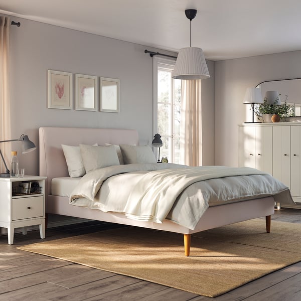 Bedroom with IDANÄS pink bed, white sheets, science prints, lamps, rug, and white furniture.