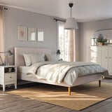 Bedroom with IDANÄS pink bed, white sheets, science prints, lamps, rug, and white furniture.