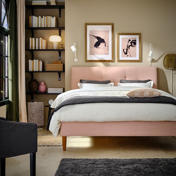 Cozy bedroom with IDANÄS bed, shelves, artwork, black chair.