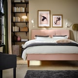 Cozy bedroom with IDANÄS bed, shelves, artwork, black chair.