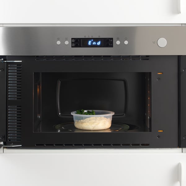 Microwave with container inside, digital display end, stainless steel front.