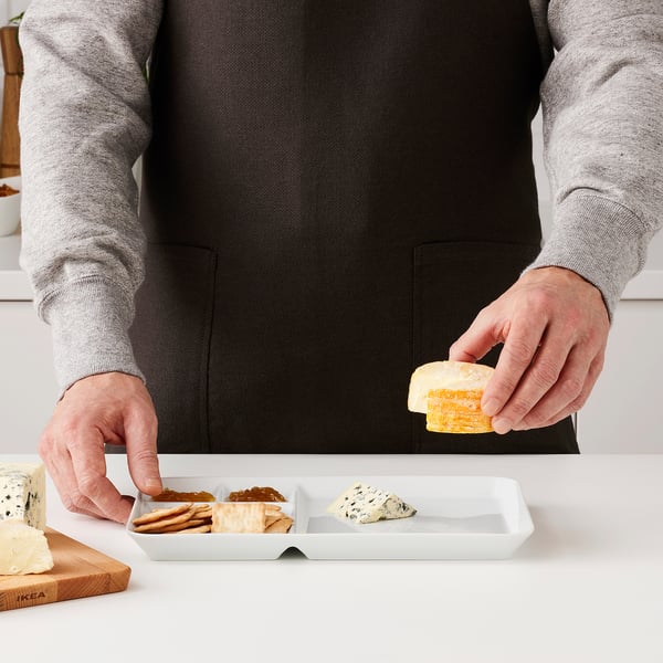 Person serving cheese on tray.