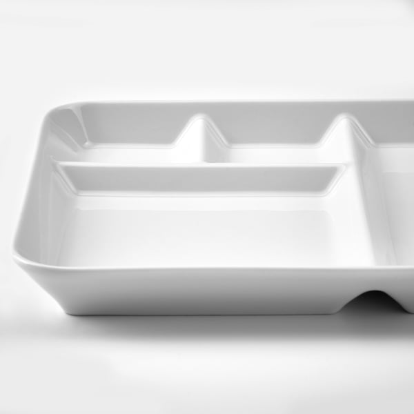 White porcelain serving dish, rectangular with curved edges, glossy finish, placed on a plain white surface.
