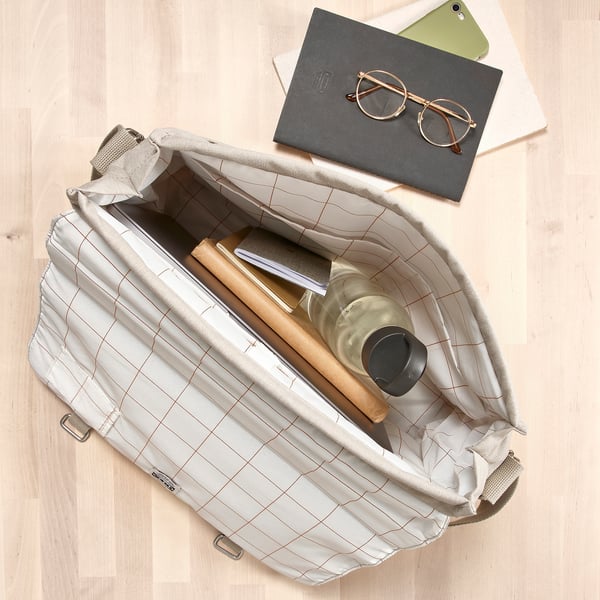 Open bag reveals water bottle, laptop, and notebook, showcasing its capacity for daily essentials.