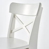 White junior chair with curved back, cross-patterned backrest, and flat seat. Designed for childrens comfort and support.