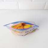 Blue IKEA resealable bag of frozen food on white shelf.