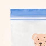 Clear plastic bag with blue seal, partially closed, featuring a cartoon bear head. High-quality, reusable, and leak-proof.
