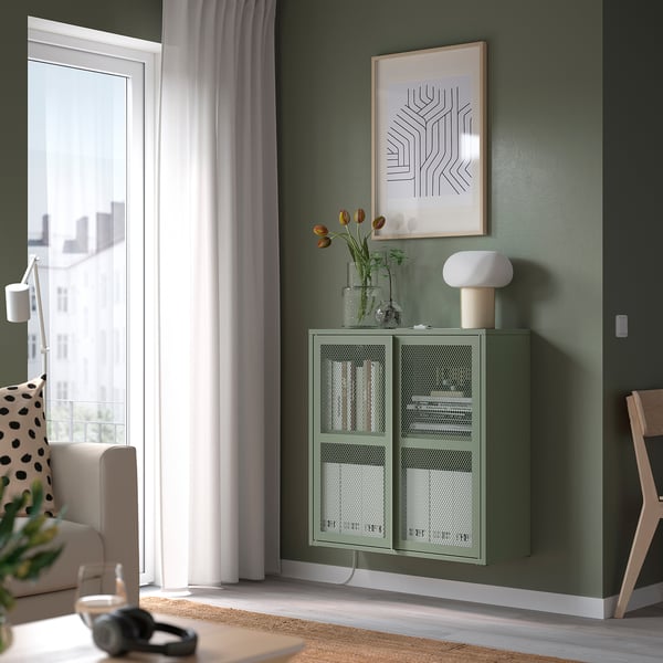 Green mesh cabinet with lamp, vase of tulips, art.