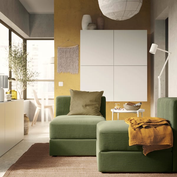 Modern living room with green textured JÄTTEBO sofa, plush pillow, wooden decor, and yellow wall.
