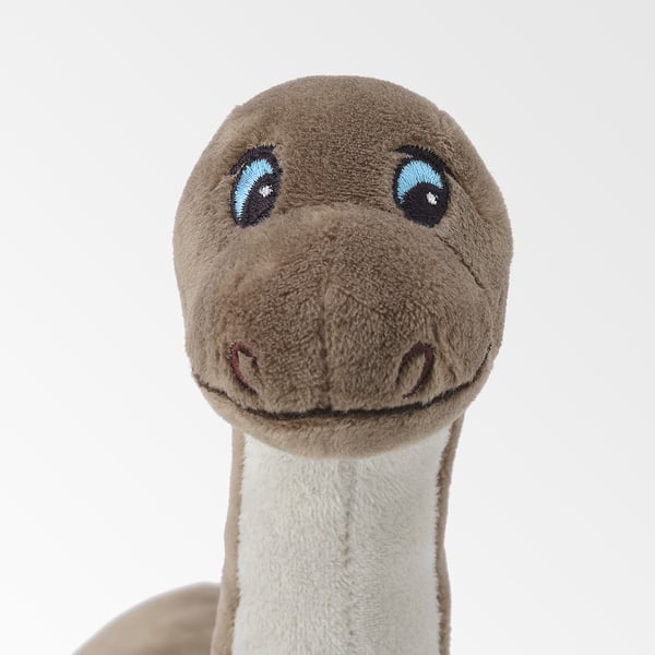 Stuffed dinosaur toy with light brown body, white underbelly, blue eyes, and stitched smile, showcasing quality craftsmanship.