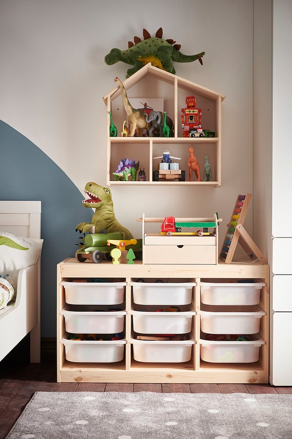 Kids room with dinosaur decor, toy shelf & storage unit.