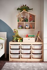 Kids room with dinosaur decor, toy shelf & storage unit.