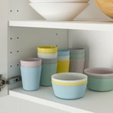 Colorful kids bowls and cups stack neatly for space-saving storage, ideal for learning to eat independently.
