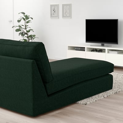 Modern living room with KIVIK green chaise, wooden floor, white walls, tv, and plant.