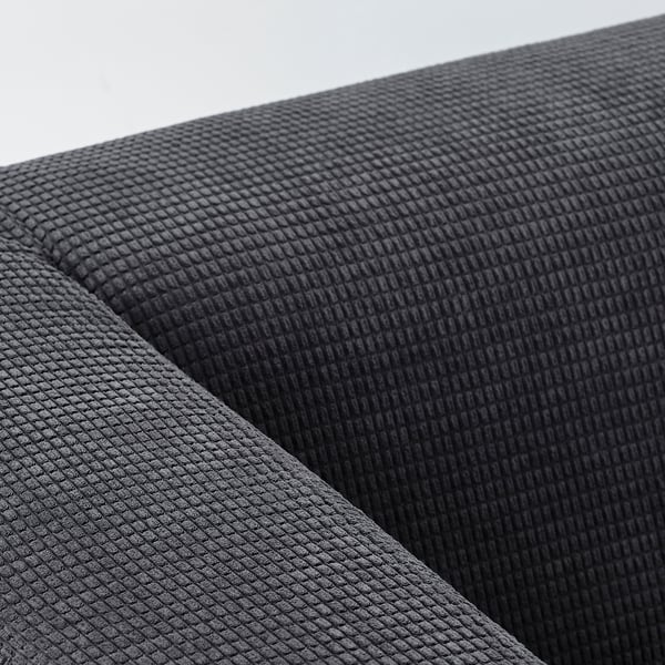 Close-up of a black fabrics, resembling sofa upholstery, with a textured, quilted pattern.