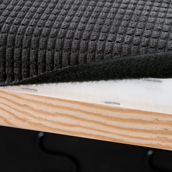 Close-up of sofa cushion attachment. Hook-and-loop fasteners secure the cover to wooden base.