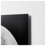 Black and white artwork on metallic surface, slightly raised edge, mounted on wall.