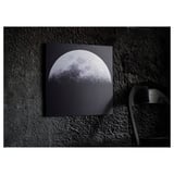A KOPPARFALL black metal picture stand with a moon design, displaying a 3d-like effect against a dark wall.