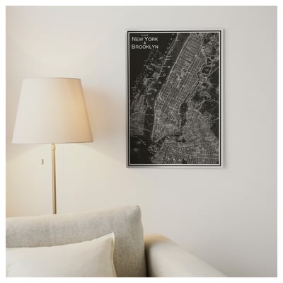 Wall-mounted ny & brooklyn map poster between couch & lamp.