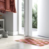 Orange KÖRFÄLTSPIL mat with white dots, window-sized.