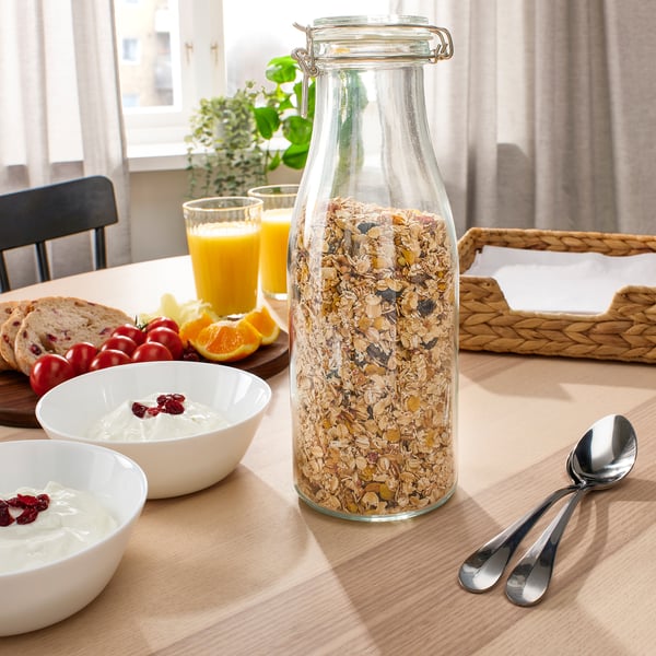 Breakfast table with KORKEN jar of granola, bowls of yogurt, fresh fruits, and orange juice.