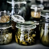 Several glass jars with metal clamps store pickles and other preserved foods. The jars have airtight seals, ensuring freshness.