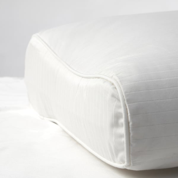 Close-up of plush, white pillow with smooth fabric and neatly stitched seams, showcasing high-quality craftsmanship.