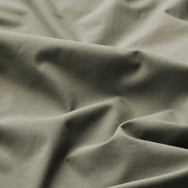 Close-up of soft, textured fabric in earthy green. Shows natural weave and gentle folds.