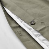 Close-up of green duvet cover with button, showing soft fabric and moisture-absorbing cotton/viscose blend.