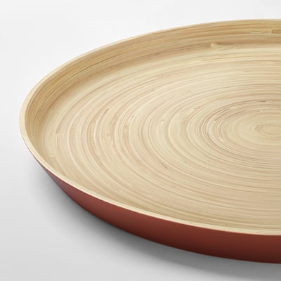 Circular bamboo serving tray with red edge & light wood grain pattern, elegant design.