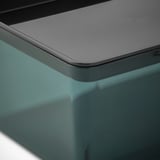 Close-up of a sleek, modern plastic box lid, smooth and reflective, with a recycled material base.