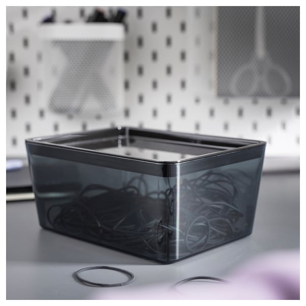 KUGGIS grey plastic box on a sink, rectangular shape, clear lid, holding a hair accessories.